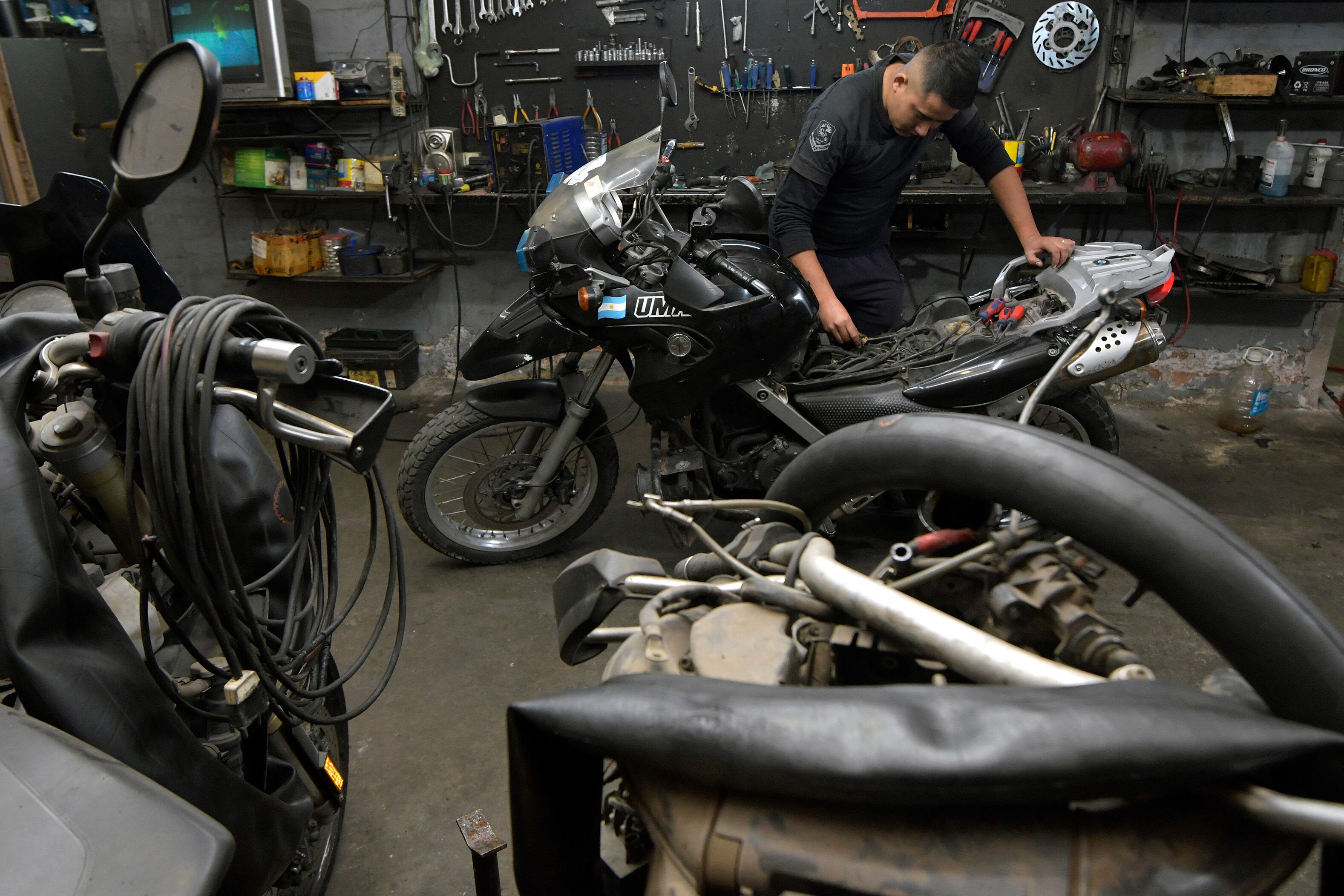 El auxiliar Claudio Villegas trabaja en la reparación de la moto que acaba de llegar de las calles. Foto: Orlando Pelichotti / Los Andes