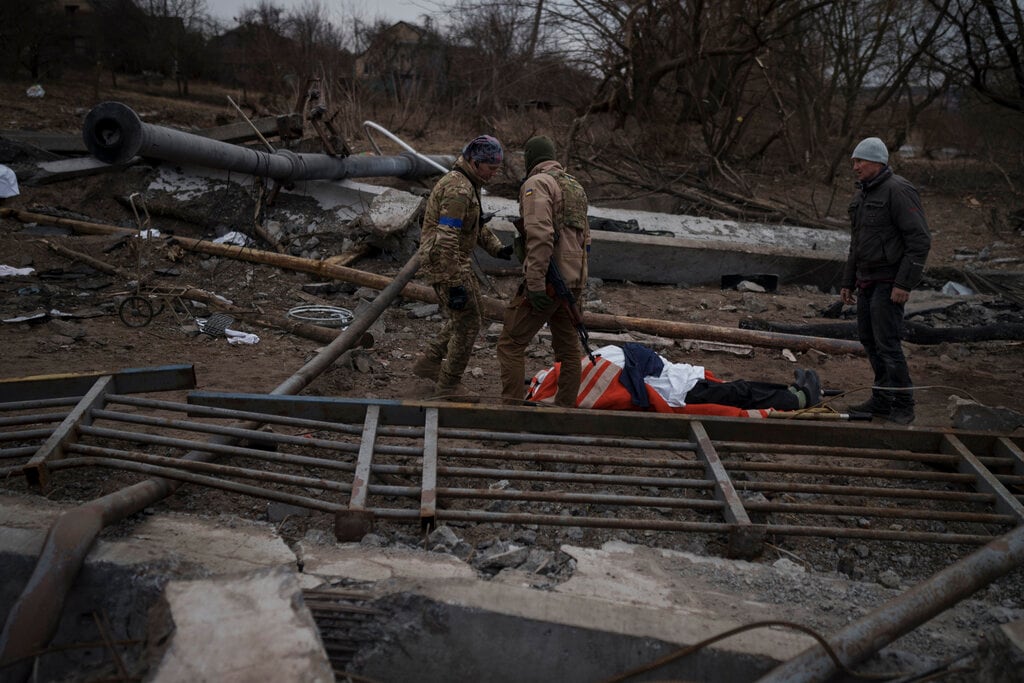 El cuerpo de un civil, que murió por causas desconocidas, yace en una camilla en un camino empleado como ruta de evacuación para salir de Irpín. Foto: AP / Felipe Dana