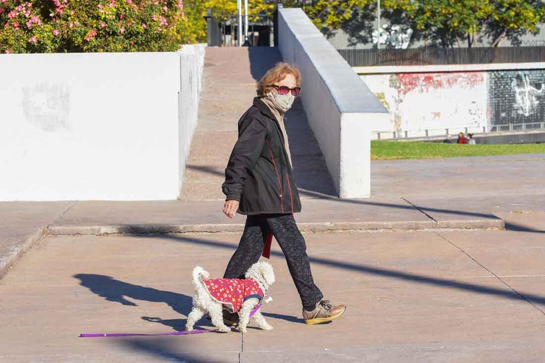 Una señora pasea con su perrito en el Parque Central de Ciudad. Ya rigen las nuevas restricciones decretadas por el Gobierno Nacional.