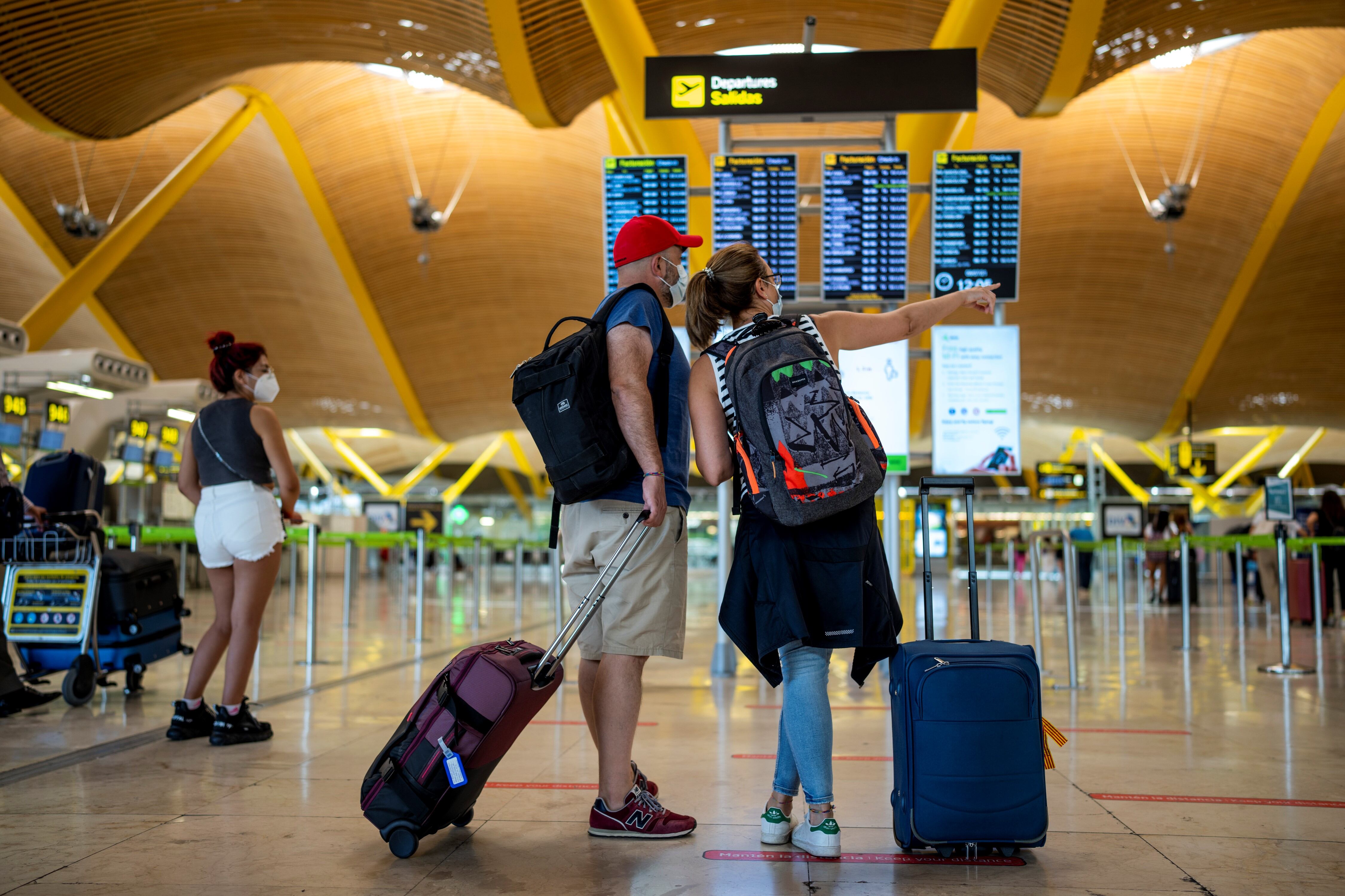 Los pasajeros revisan la pantalla de salida en el aeropuerto internacional Adolfo Suárez-Barajas en Madrid. Foto: AP