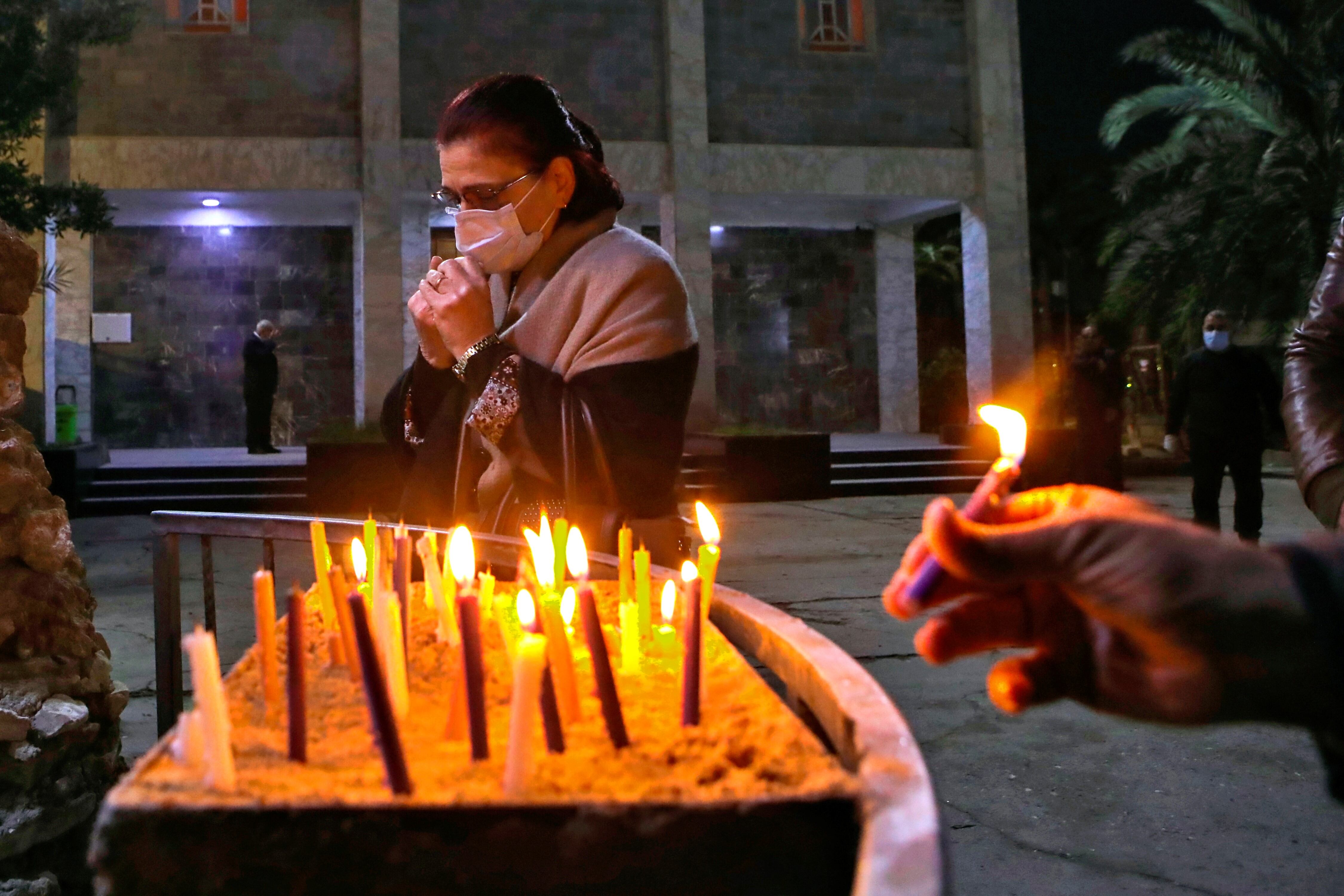 Las velas encendidas por los fieles se ven colocadas en la puerta de la Catedral del Hogar Sagrado, que está cerrada al público en general debido a las restricciones de COVID-19 en la víspera de Navidad en Nueva Delhi, India.