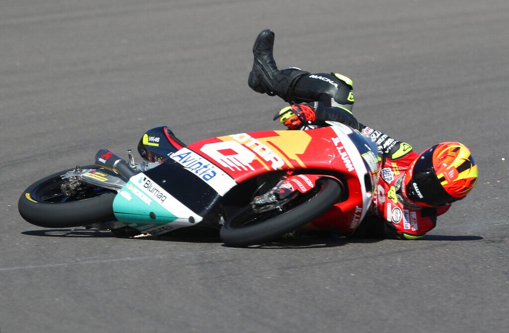 El piloto italiano de Moto3 Elia Bartolini, del QJMOTOR Avintia Racing Team, cae al asfalto durante una práctica libre en el circuito de Termas de Río Hondo, Argentina, el 2 de abril de 2022. (AP Foto/Nicolás Aguilera)