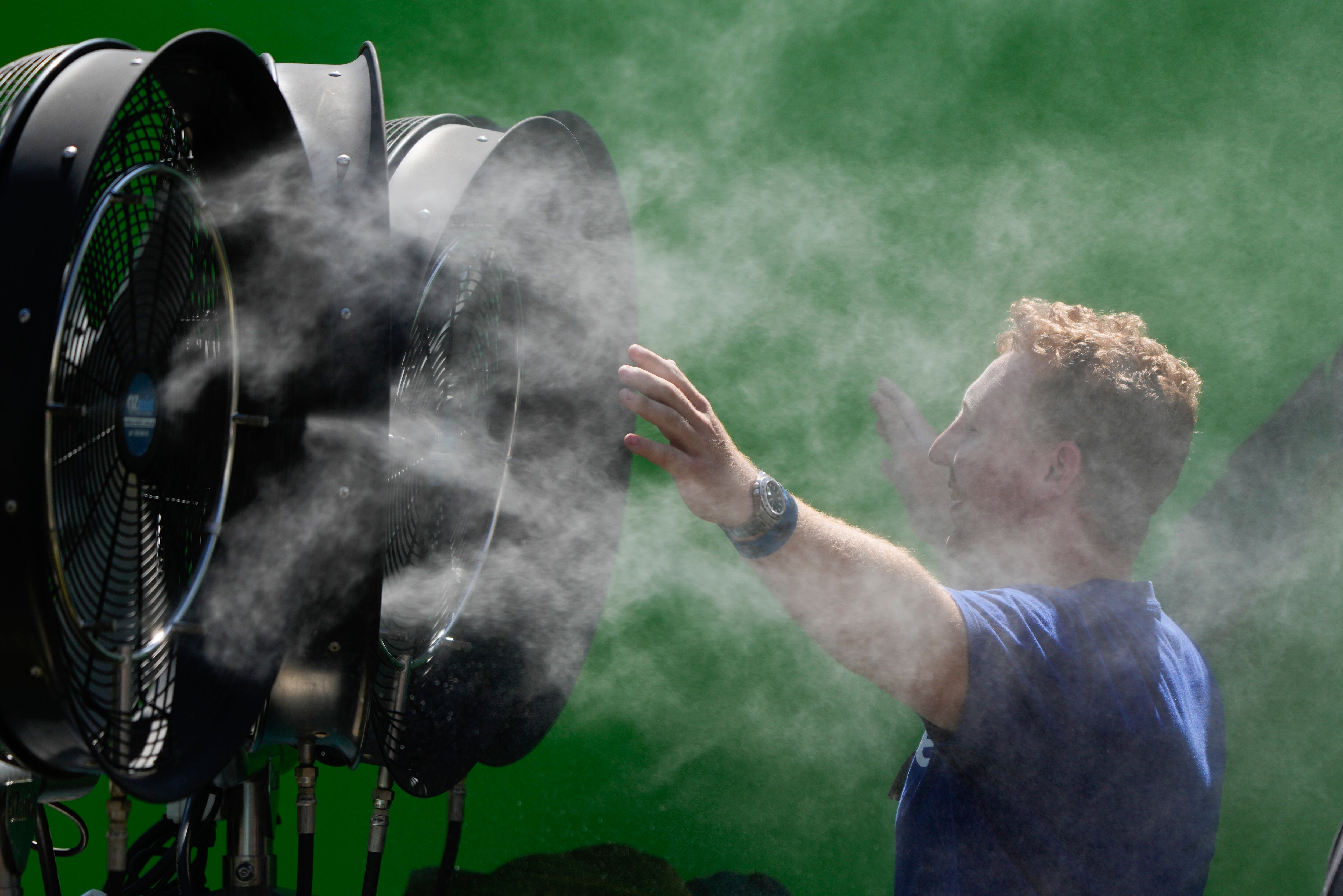 ARCHIVO - Un espectador se refresca durante una jornada de entrenamiento previa al Abierto de Australia en Melbourne Park, Melbourne, Australia, 12 de enero de 2024. (AP Foto/Andy Wong, Archivo)