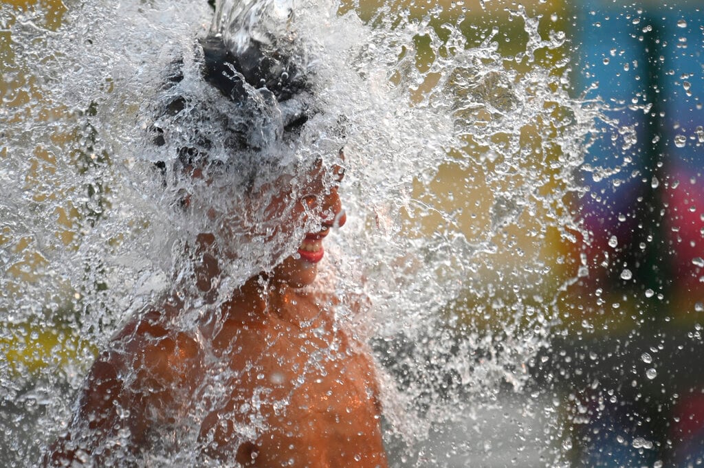 Un niño se refresca en plena ola de calor estival en Buenos Aires, Argentina, el 14 de enero de 2022. (AP Foto/Mario De Fina)