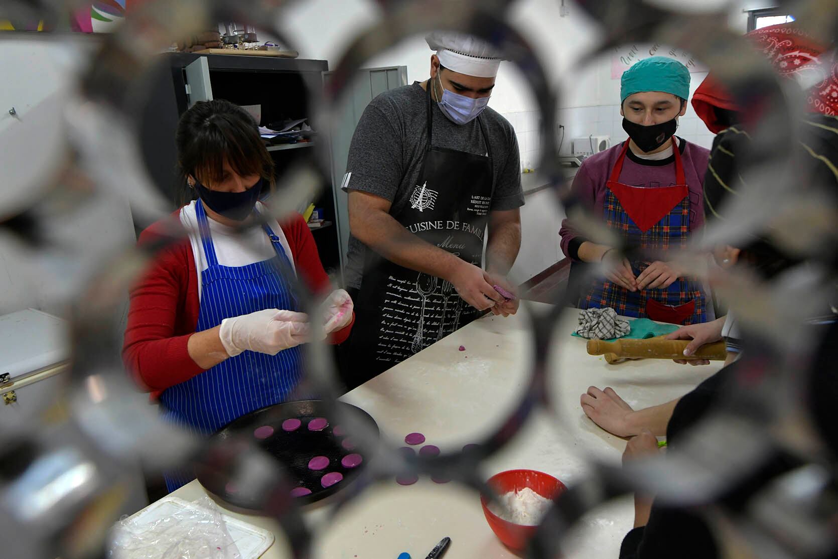 Alumnos preparan moldes de tapas de alfajores de maicena, en la clase de cocina. Foto: Orlando Pelichotti