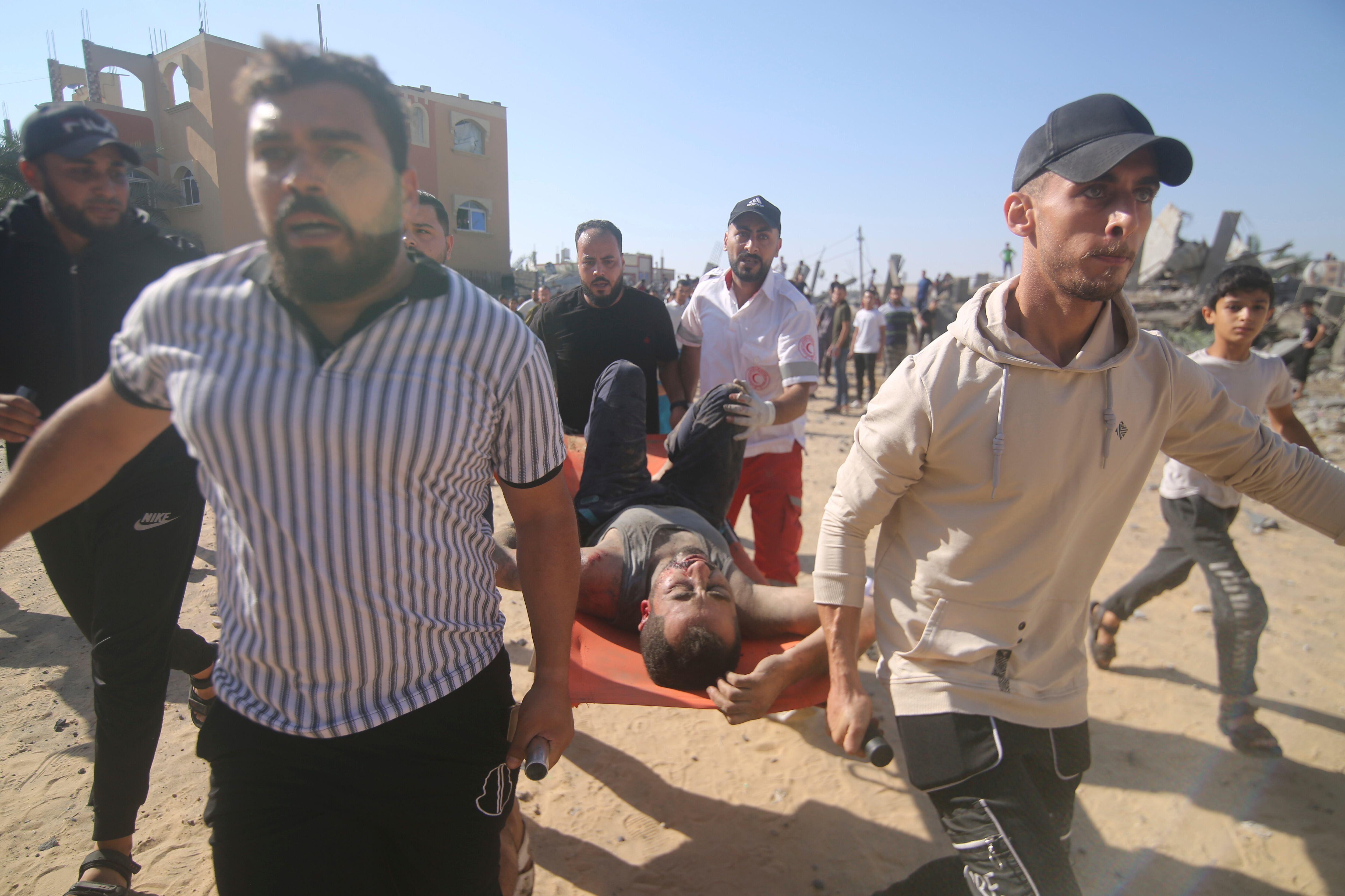 Palestinos llevan a un hombre herido de entre los escombros de un edificio derruido tras un ataque aéreo en Rafah, en la Franja de Gaza. (AP Foto/Hatem Ali)