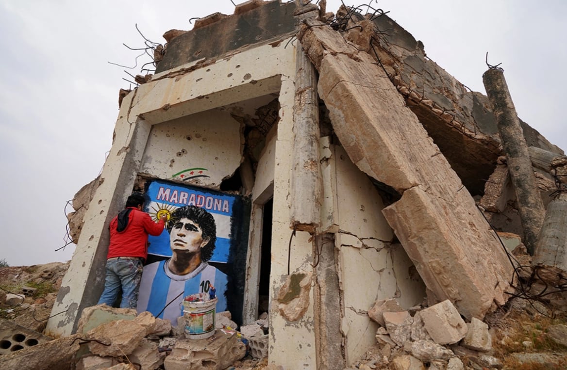 Un artista sirio realizó un mural con el rostro del '10' en una ciudad en ruinas. Foto AFP.