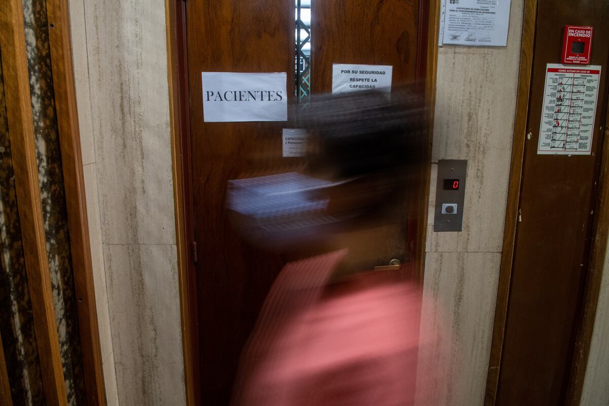 Una doctora para frente a a uno de los ascensores de uso exclusivo para pacientes.