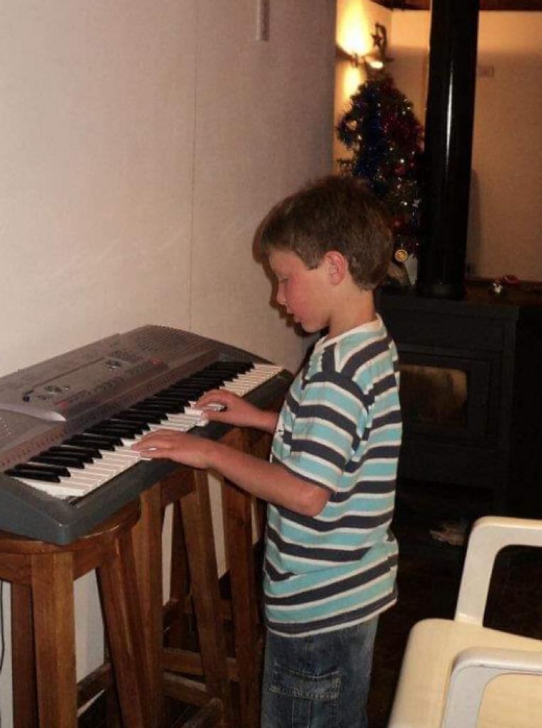 Ambrosio de niño tocando el piano.