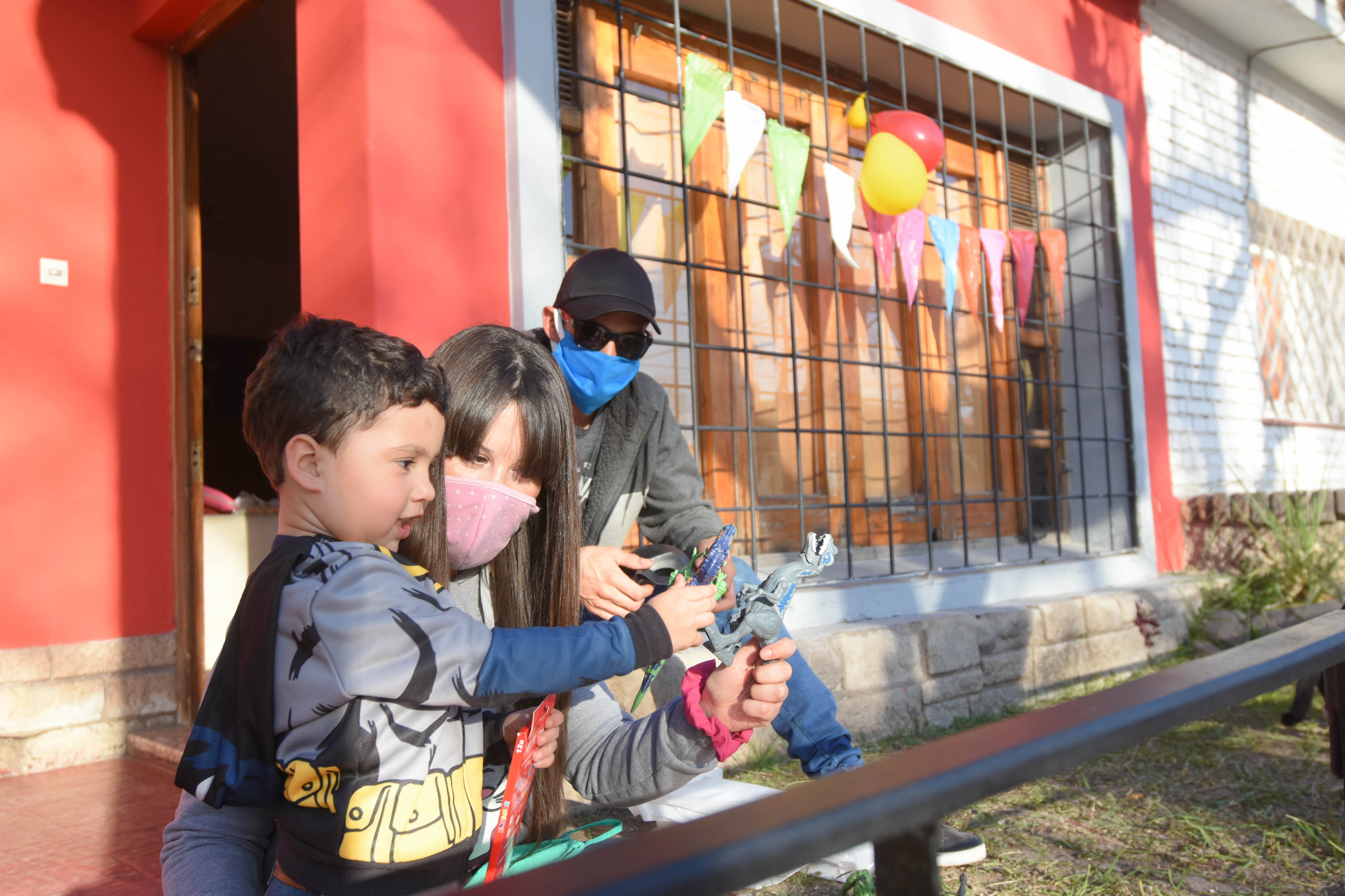 Matías y Micaela, junto a su hijo Benjamín juegan en la puerta de su casa.