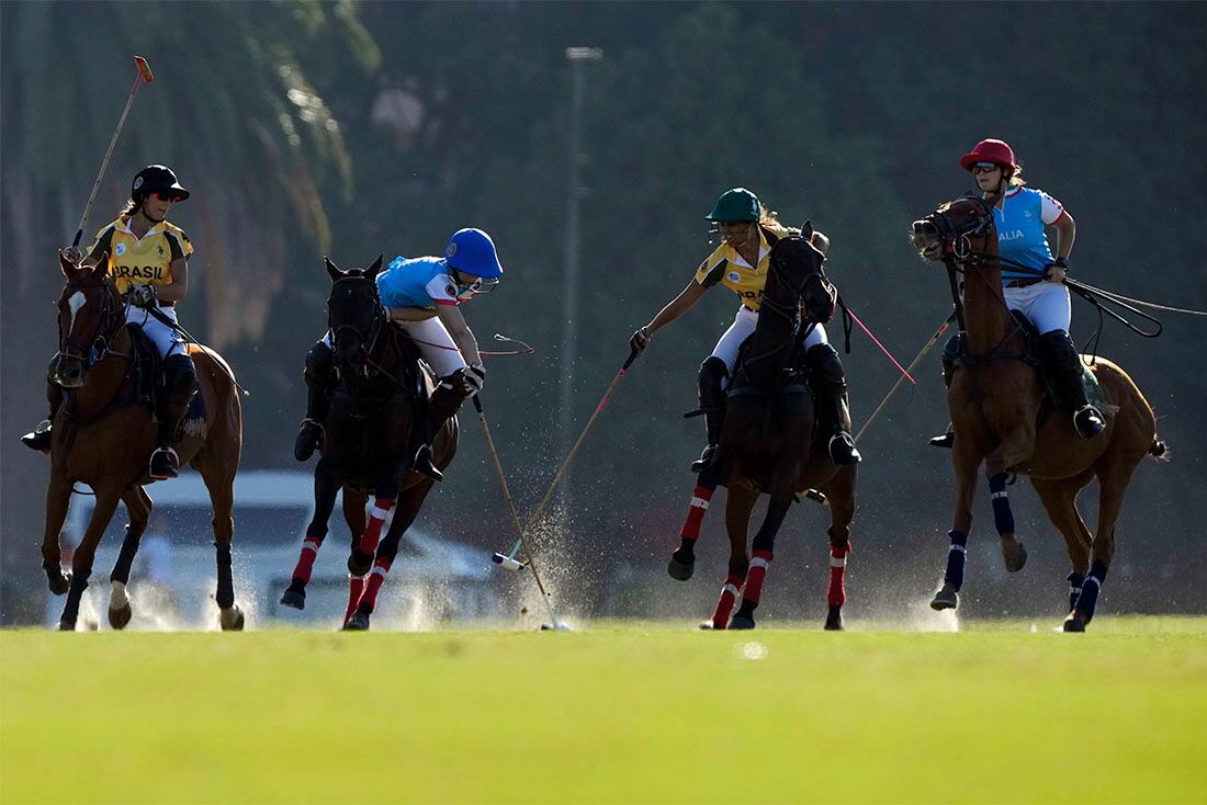 La italiana Maria Vittoria Marchiorello (centro izquierda) y la brasileña Eduarda Vilela pugnan por la pelota durante un partido del Mundial de Polo femenino en Buenos Aires, Argentina, el 9 de abril de 2022. (AP Foto/Natacha Pisarenko)