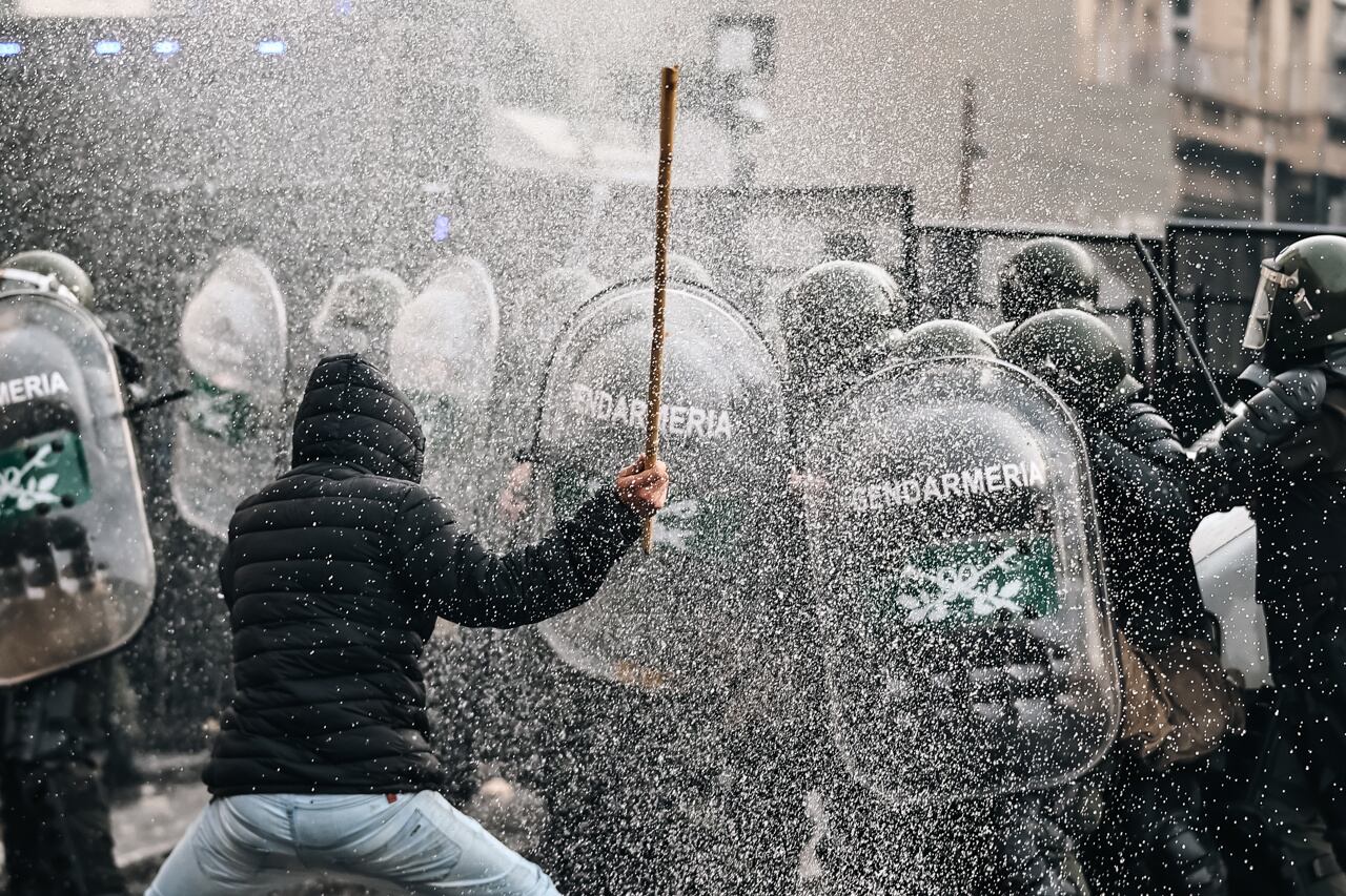 Un hombre es visto durante enfrentamientos entre la policía y personas que protestan a las afueras del senado. Foto: EFE/ Juan Ignacio Roncoroni