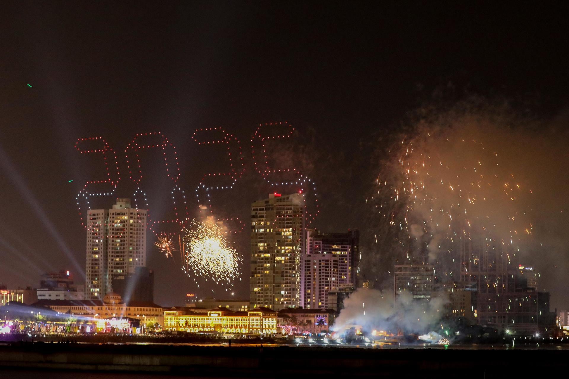 Fuegos artificiales y efectos de luz iluminan el cielo nocturno durante las celebraciones del Año Nuevo 2025 en la capital, Colombo (Sri Lanka). Foto: EFE/EPA/CHAMILA KARUNARATHNE