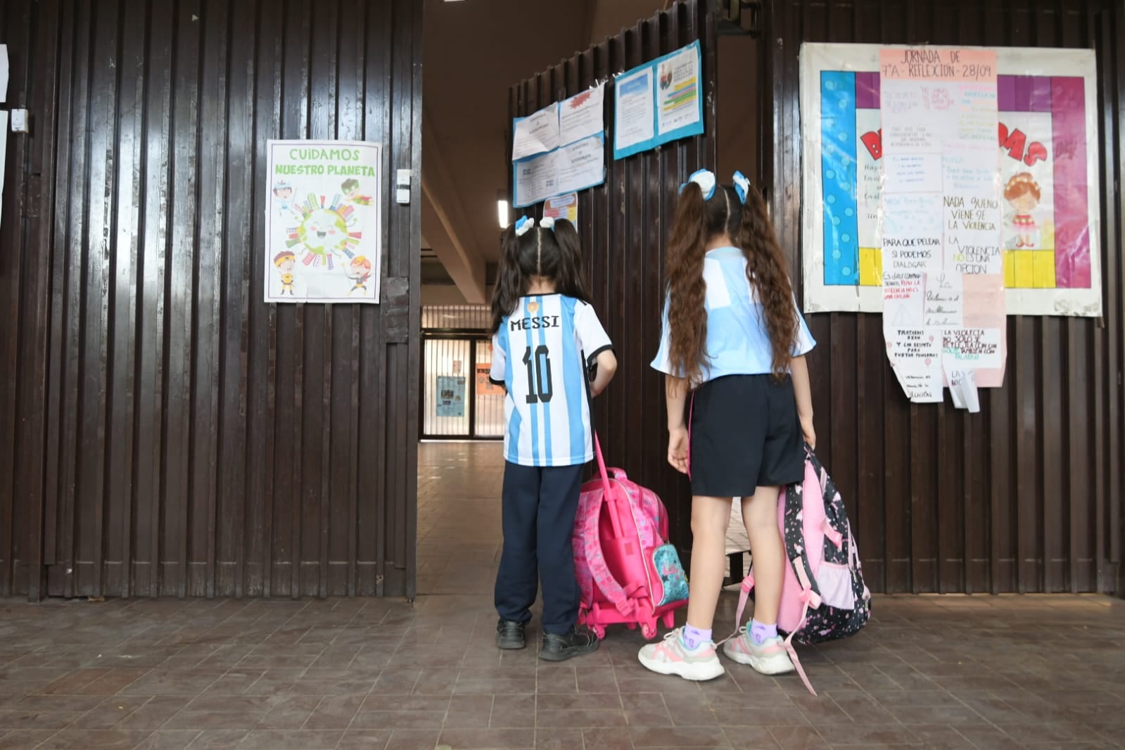 Dos alumnas esperan el permiso para ingresar a clases en la Escuela Patricias, de Ciudad, con el partido entre Argentina y Arabia Saudita ya casi "liquidado". Foto: Ignacio Blanco / Los Andes