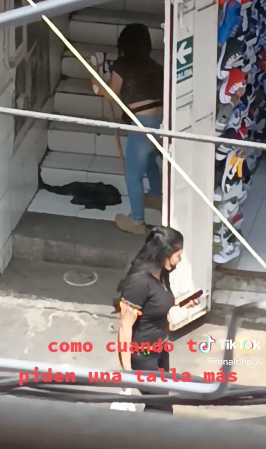 Una vendedora fue captada mientras trataba de agrandar una zapatilla con un palo de madera. Foto: Web