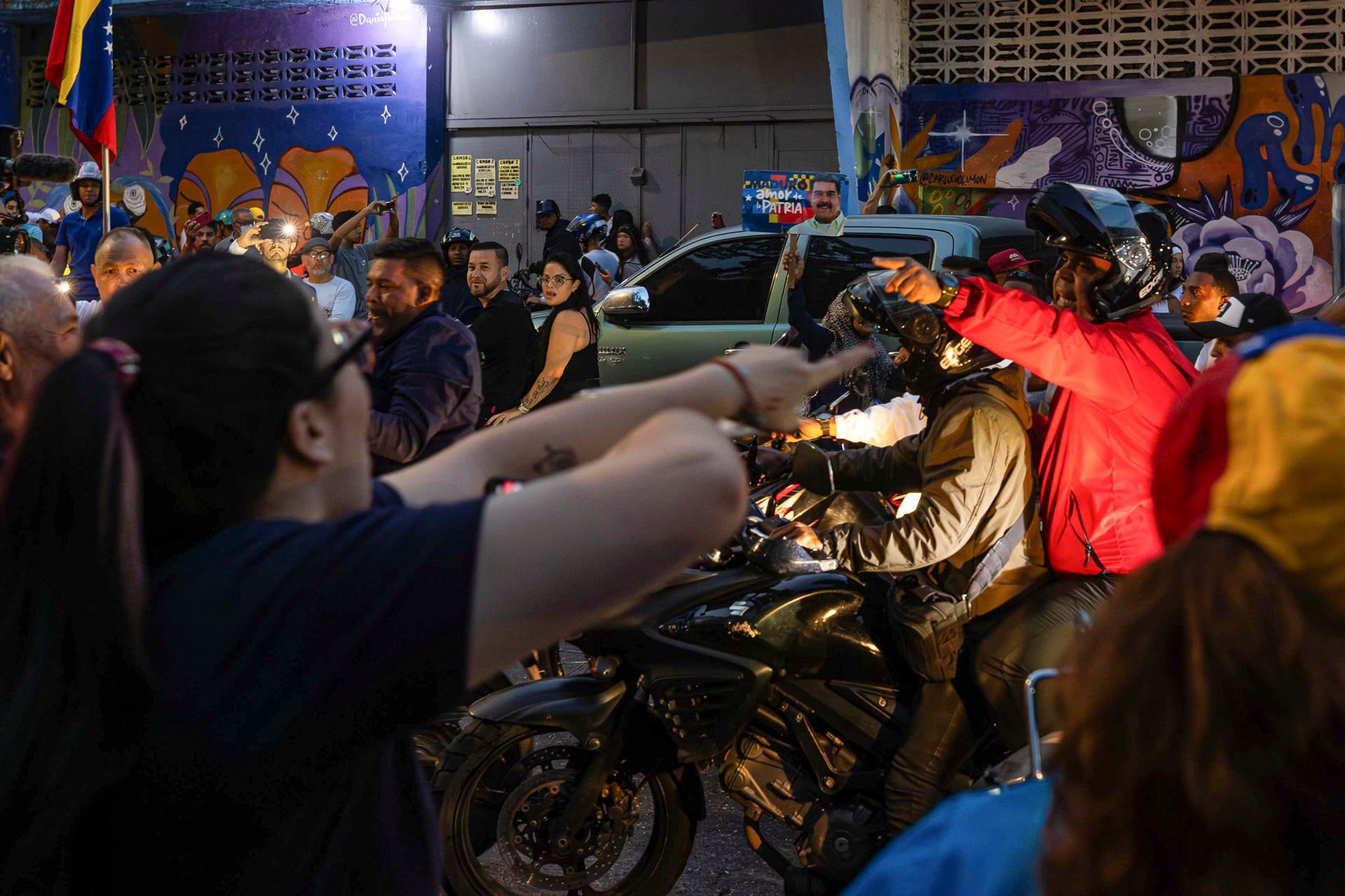 Seguidores del presidente de Venezuela y candidato a la reelección, Nicolás Maduro, se enfrentan desde una caravana de motocicletas con personas este domingo, en Caracas (Venezuela). Varias decenas de motorizados que se identificaron como chavistas llegaron a un centro de votación en Caracas, donde se encontraban testigos opositores y ciudadanos que esperaban el comienzo del escrutinio de las elecciones presidenciales de este domingo, lo que dio lugar a una confrontación que acabó a golpes, ante la mirada impasible de los policías, que no intervinieron para detener la pelea. Foto: EFE/ Henry Chirinos.