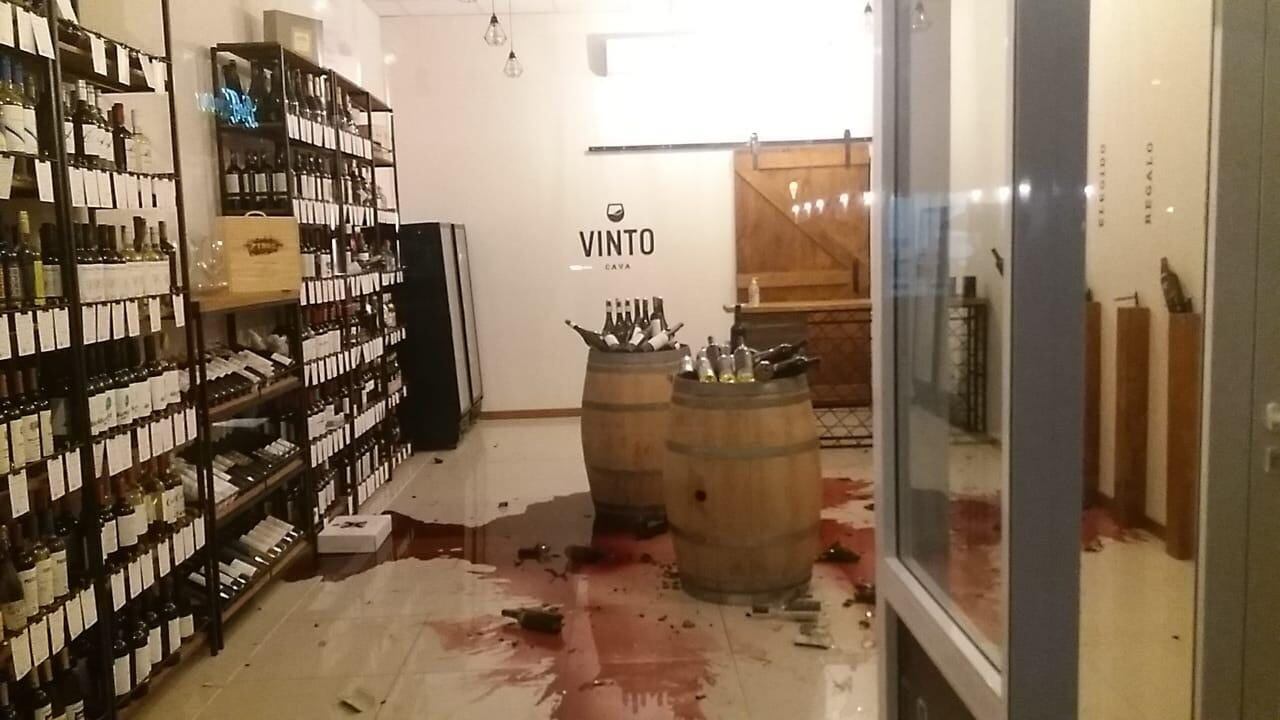 Botellas de vino rotas en el suelo de una vinería.