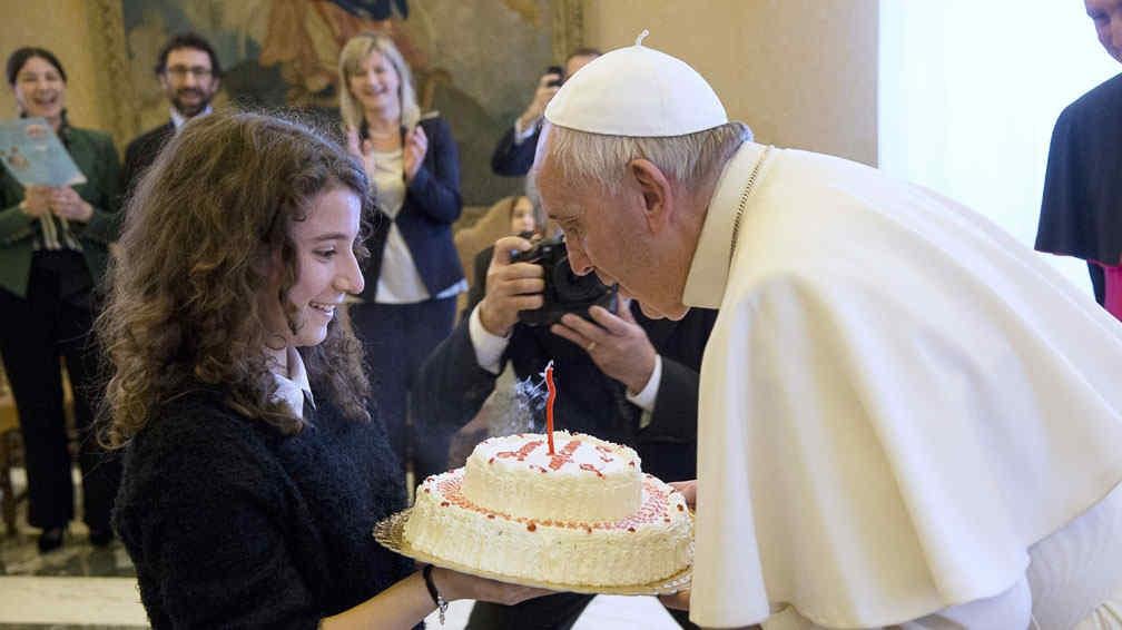 VATICANO. Una adolescente le entrega una torta de cumpleaños a Francisco (AP).