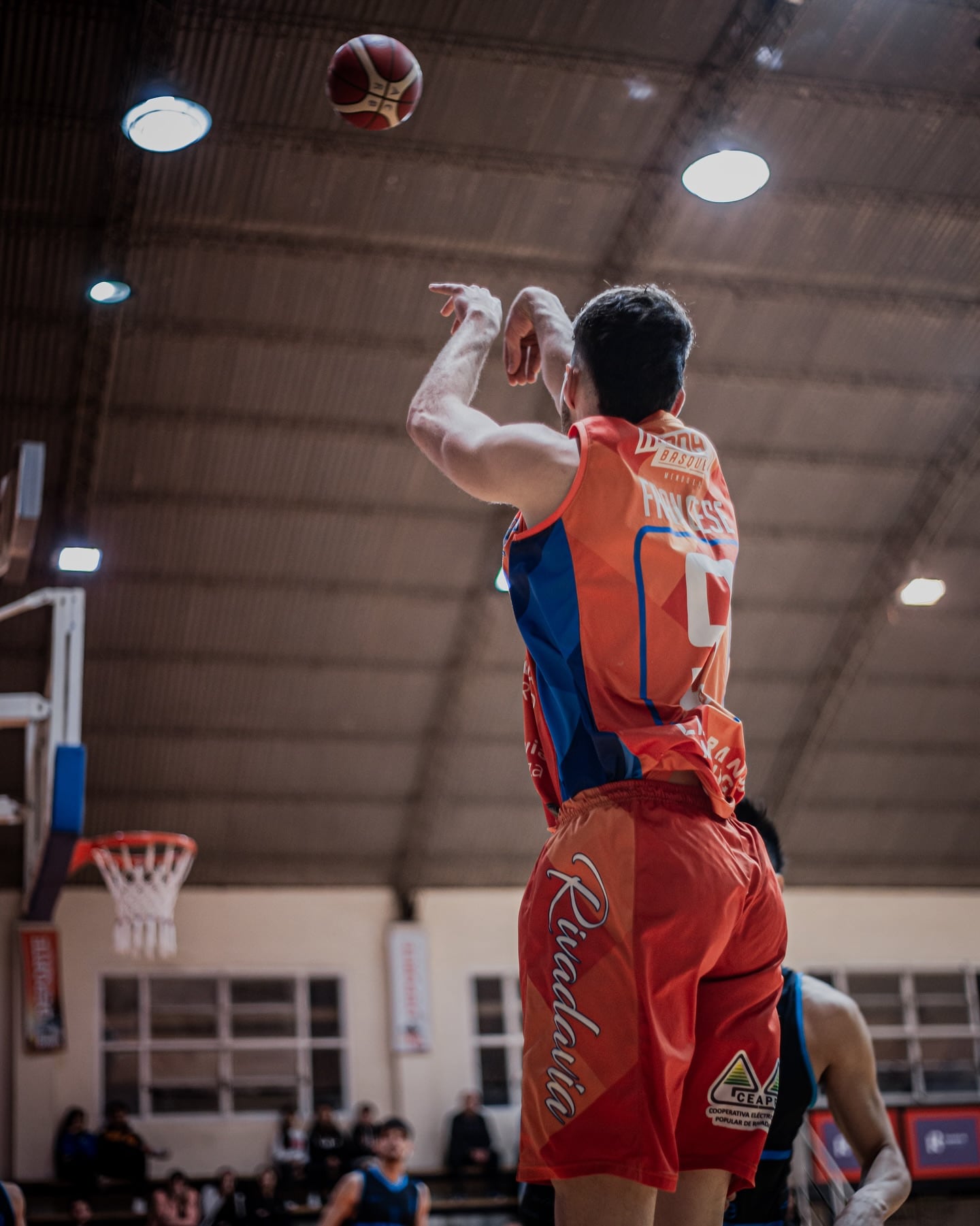 Guido Francese se eleva y convierte un triple fundamental para el Naranja. / Gentileza: Rivadavia Basquet.