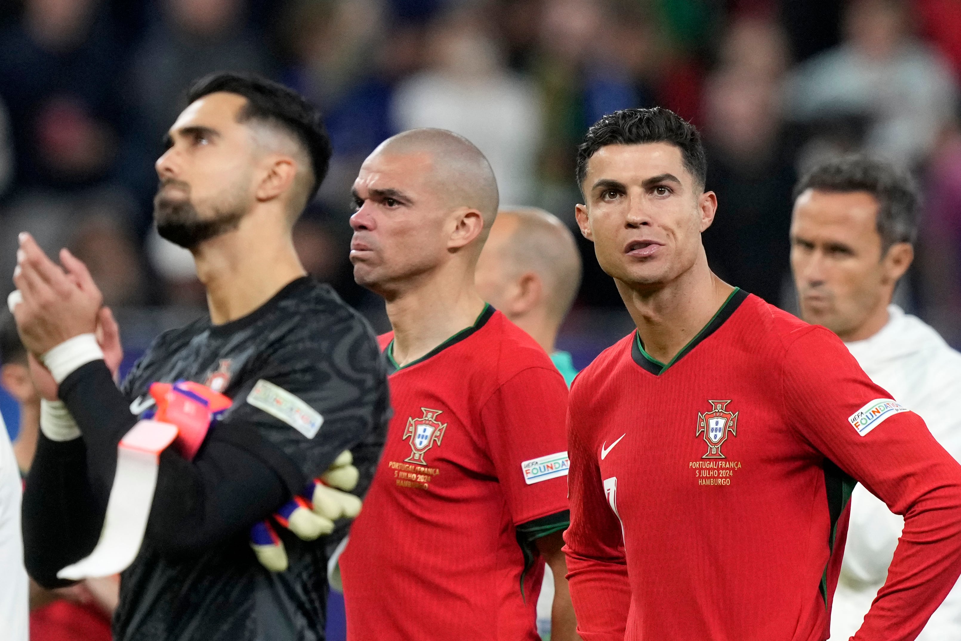 Diogo Costa, Pepe y Cristiano Ronaldo, de la selección portuguesa, se lamentan tras la derrota ante Francia por penales en los cuartos de final de la Eurocopa, el viernes 5 de julio de 2024, en Hamburgo, Alemania (AP foto/Martin Meissner)