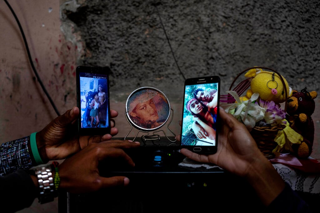 Familiares muestran fotos de tres hermanos romaníes que están en la cárcel acusados de participar en protestas antigubernamentales, en su casa en el vecindario de La Guinera, en La Habana, Cuba