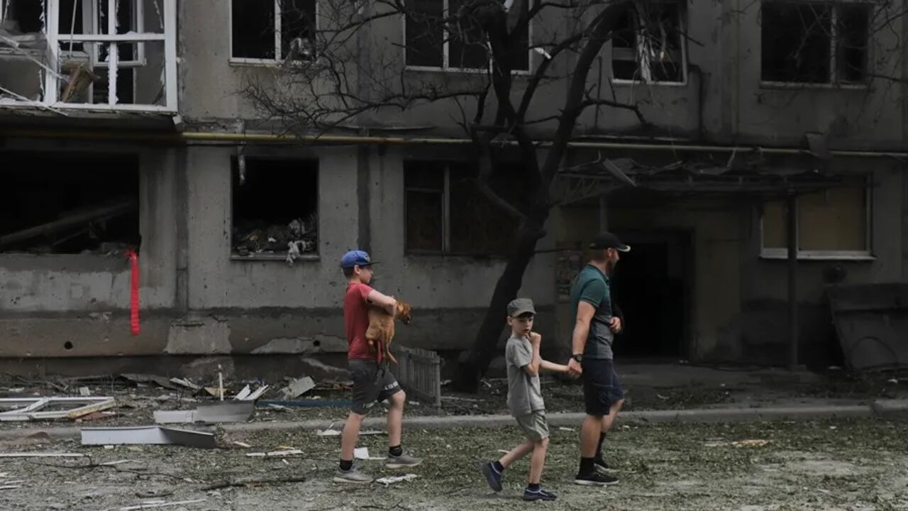 Familia en una calle de la ciudad ucraniana de Bajmut, en la que se muestran los efectos de los bombardeos rusos. Foto: EFE/EPA