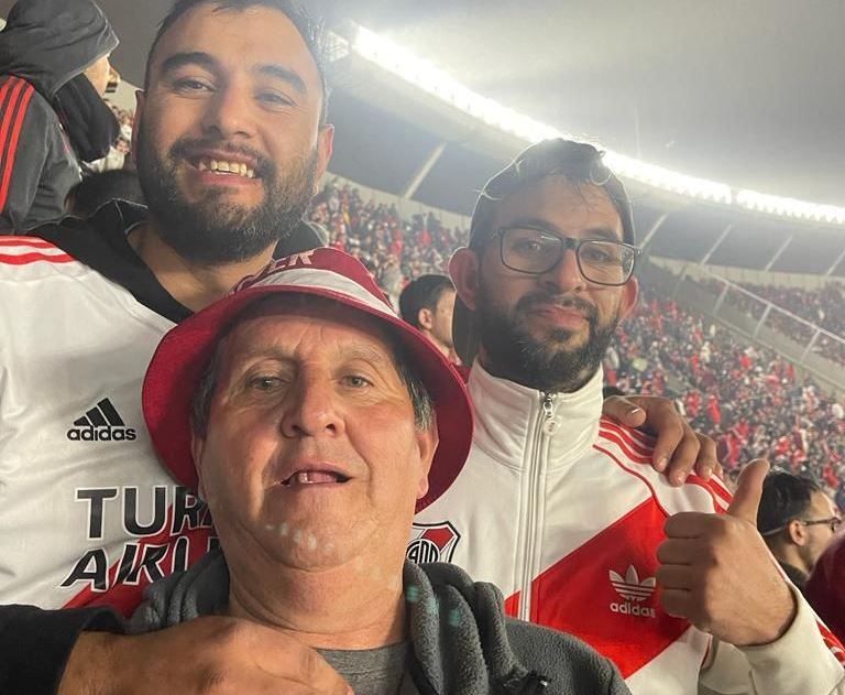 Martín (de lentes) junto a su hermano Juan Pablo y a su padre, a quien le cumplió el sueño de conocer la cancha de River.