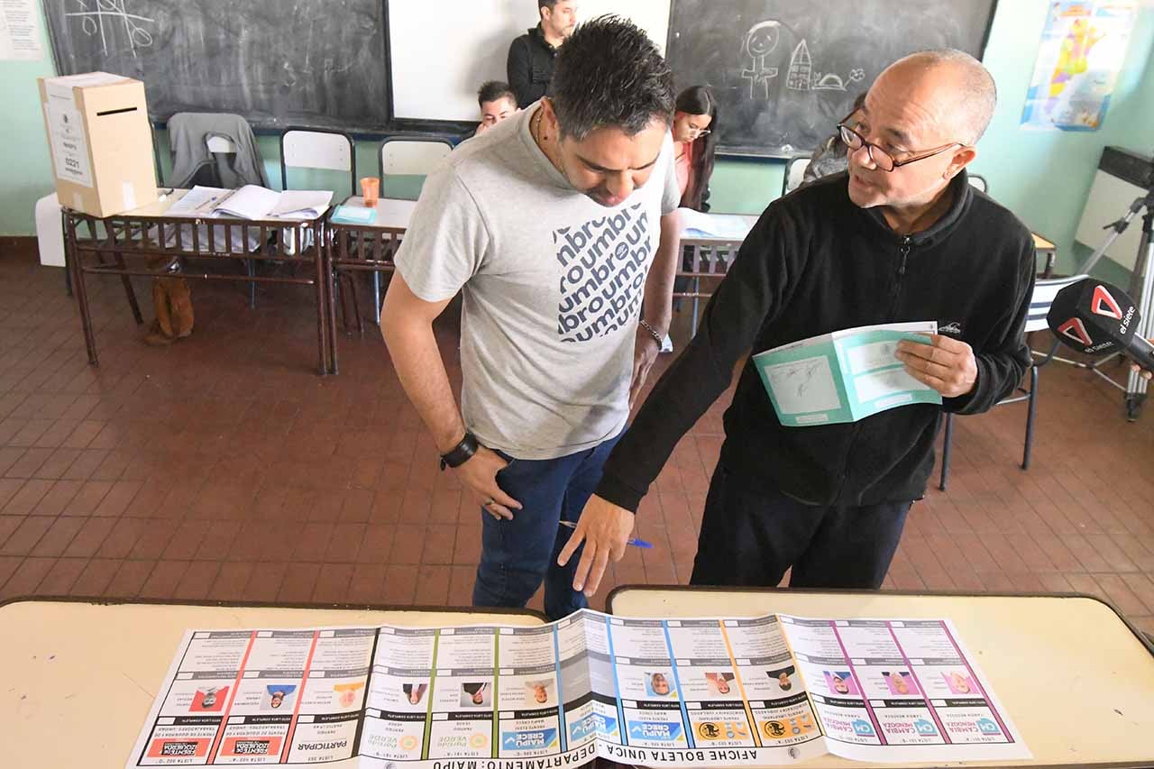 El Presidente de mesa, explica a un votante el sistema de realizar el voto
Foto:José Gutierrez / Los Andes 